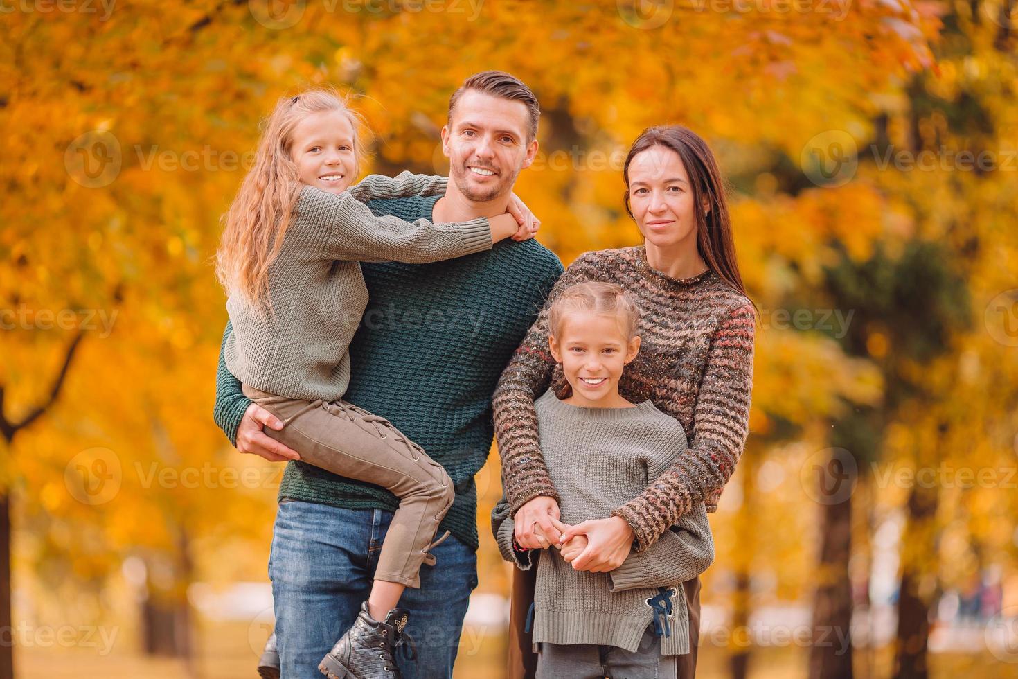 retrato de familia feliz de cuatro en otoño foto