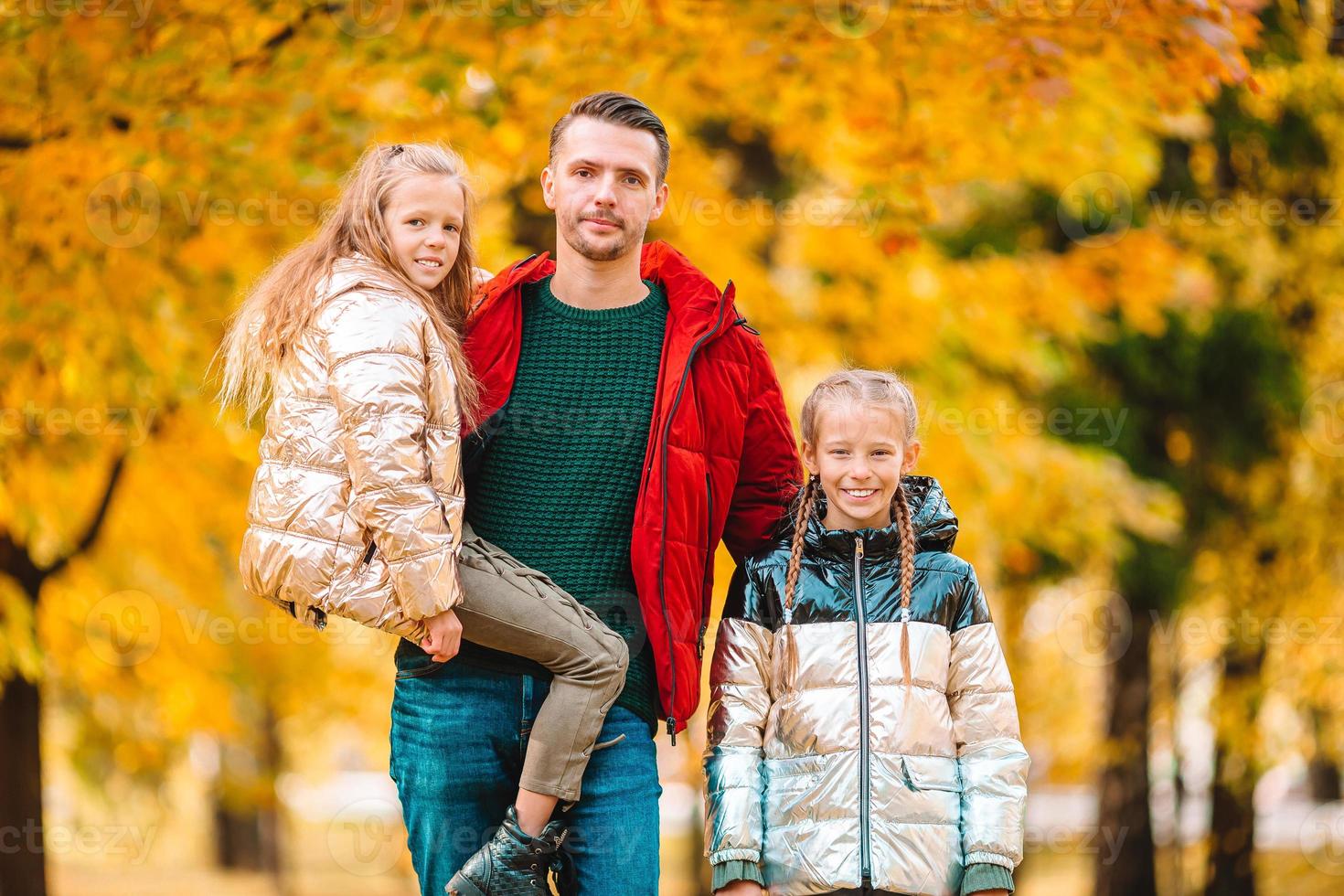Family of dad and kids on beautiful autumn day in the park photo