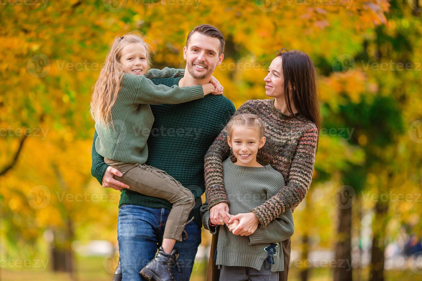 retrato de familia feliz de cuatro en otoño foto