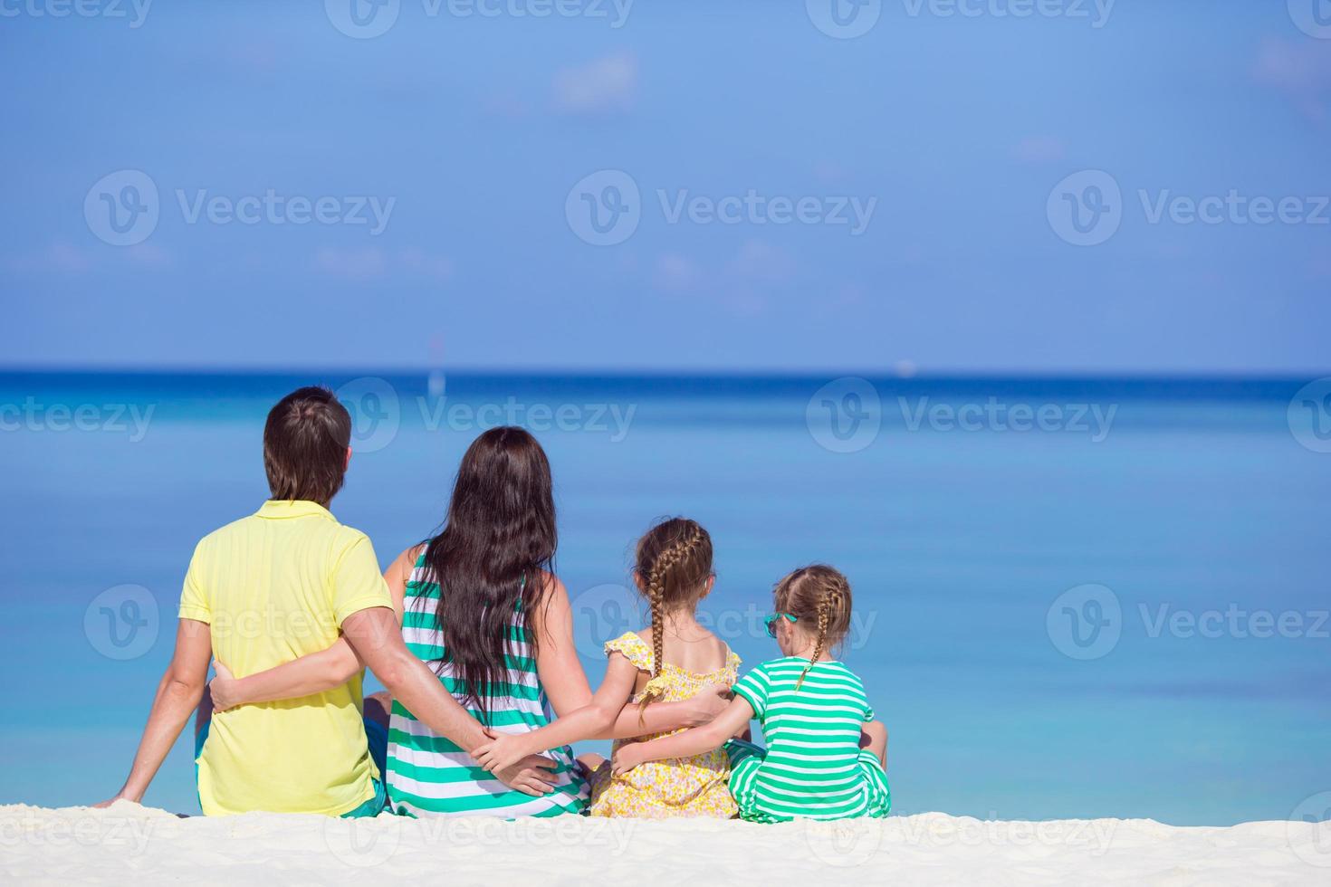 Happy family having fun on white beach photo