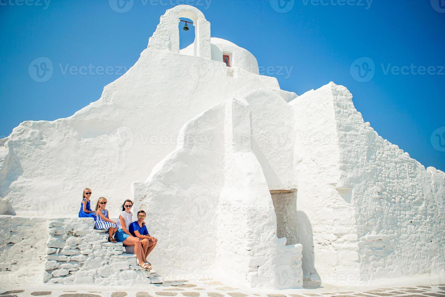 Family of four on the stairs of Paraportiani church on Mykonos photo