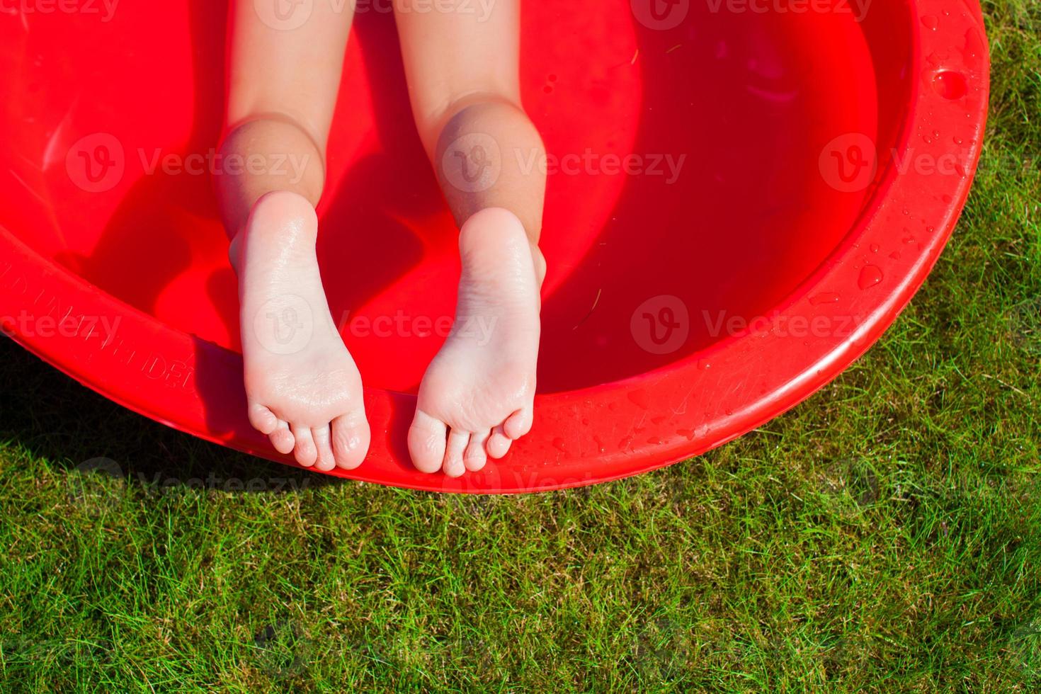 primer plano de las piernas de una niña en la piscina foto