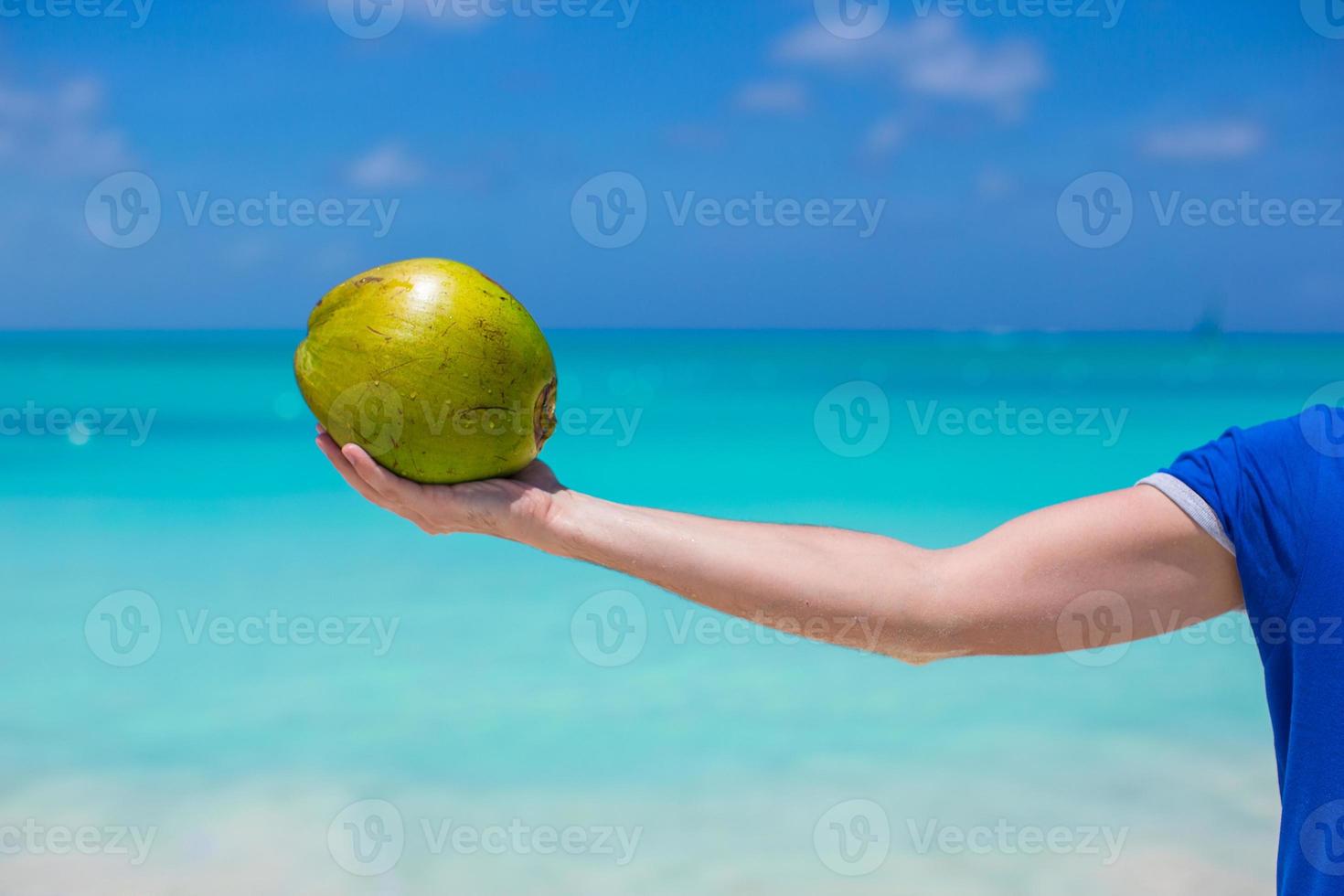 Closeup of coconut in hands background the turquoise sea photo