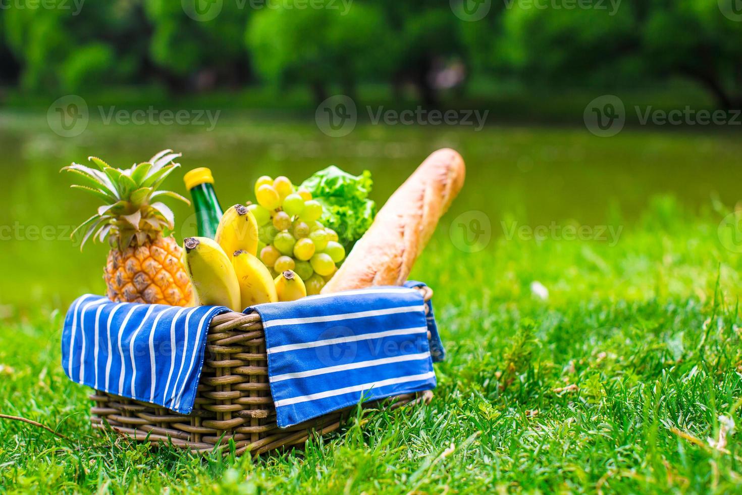 Picnic setting with white wine, pears, fruits, bread photo