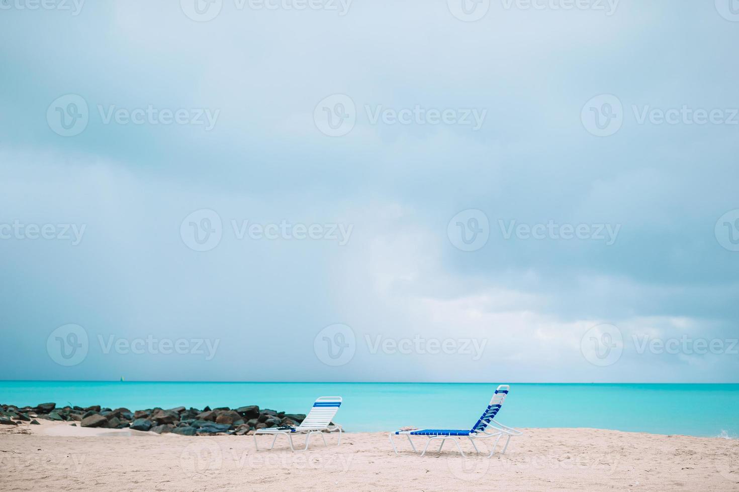 White lounge chairs on a beautiful tropical beach at Maldives photo