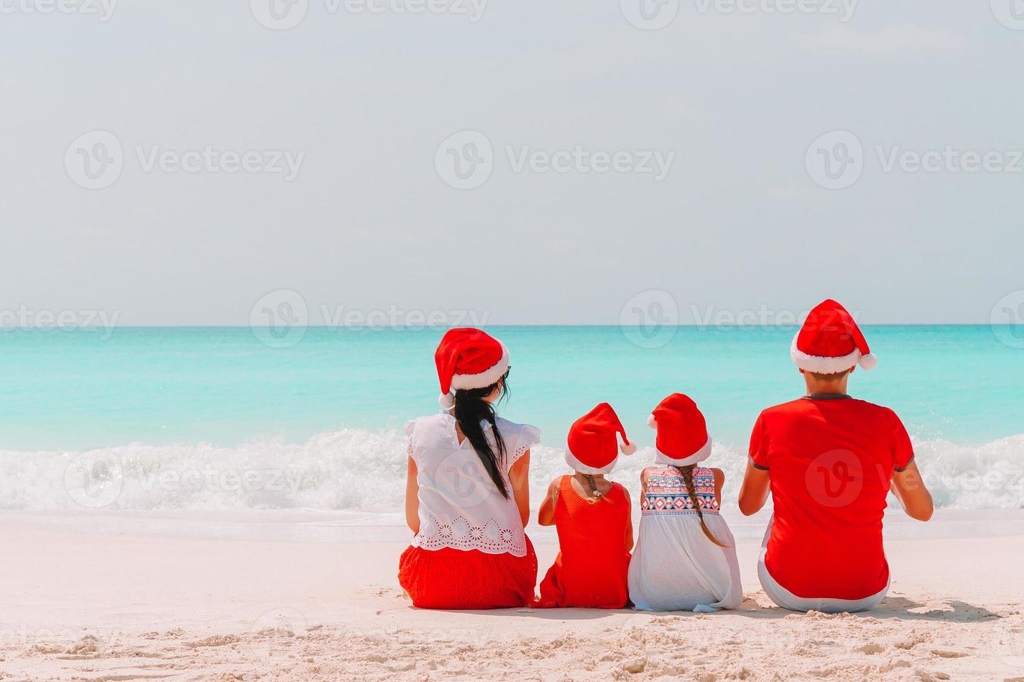 Happy family with two kids in Santa Hat on summer vacation photo