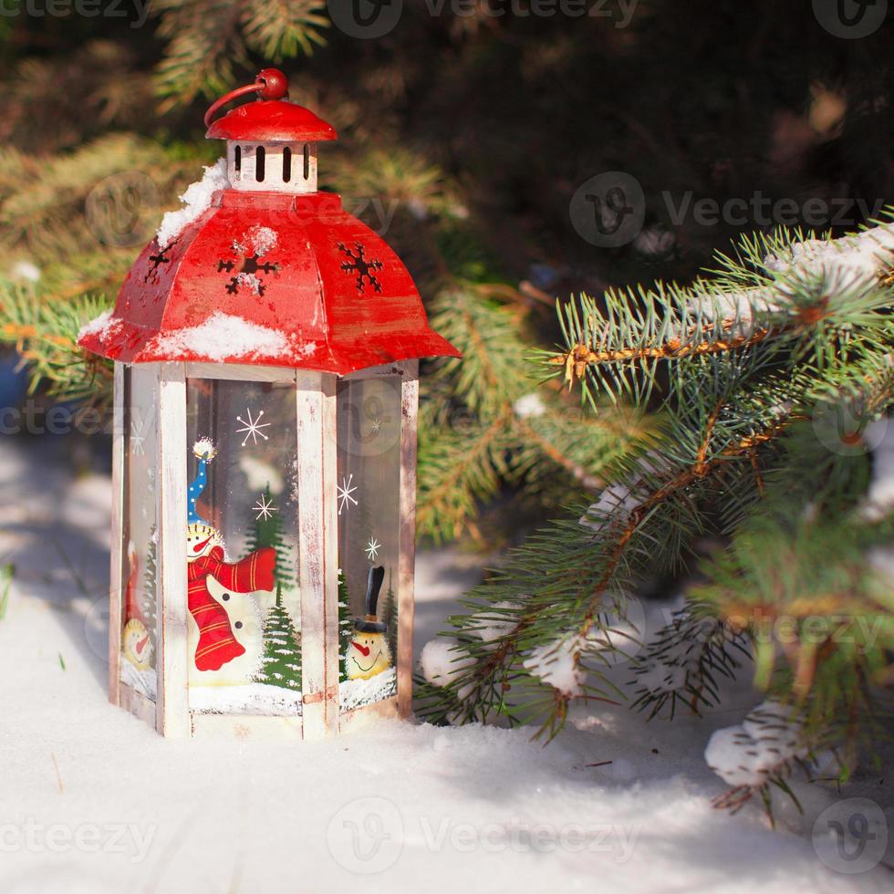 Beautiful red fairytale lantern on white snow in forest photo