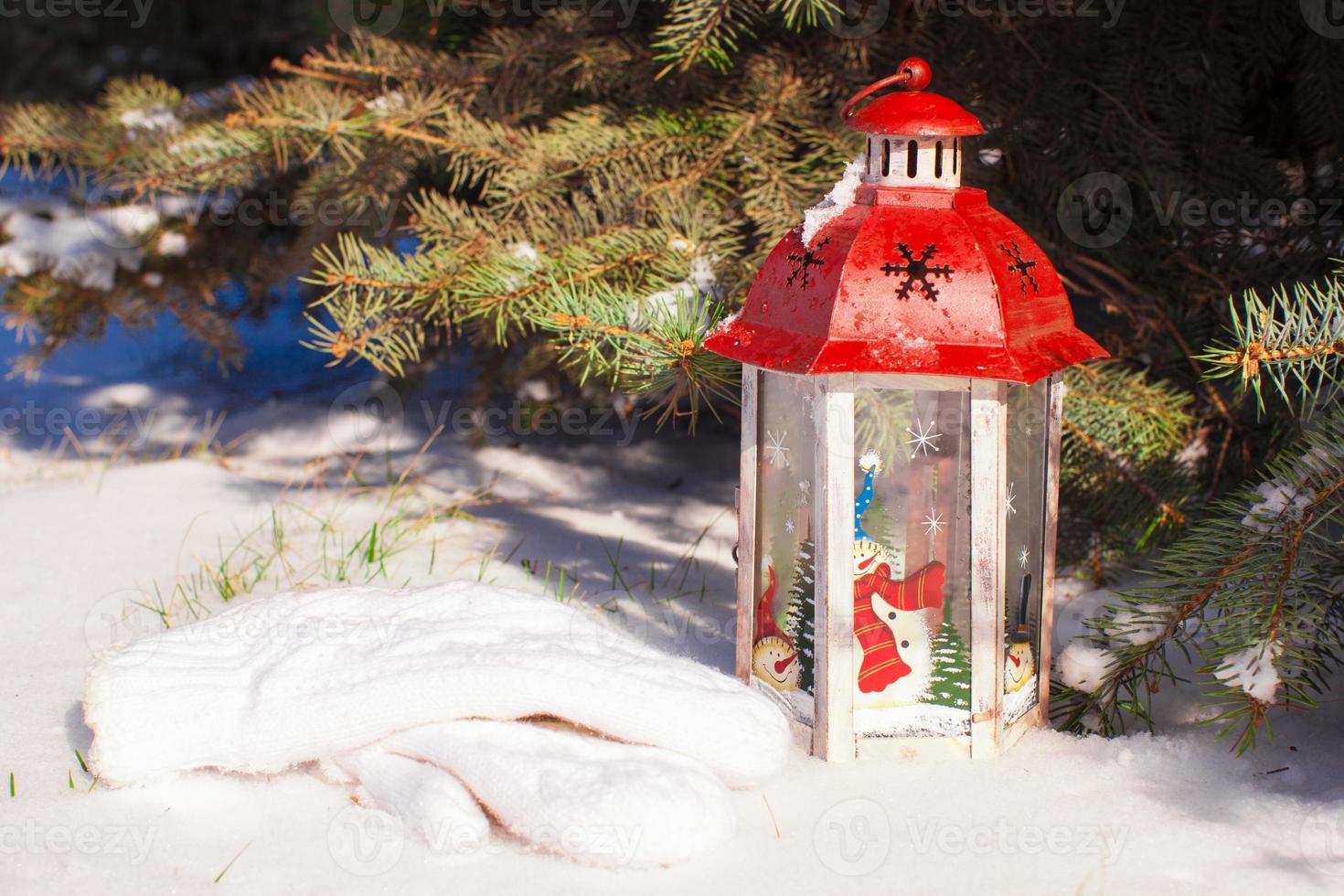 Beautiful red fairytale lantern on white snow in forest photo