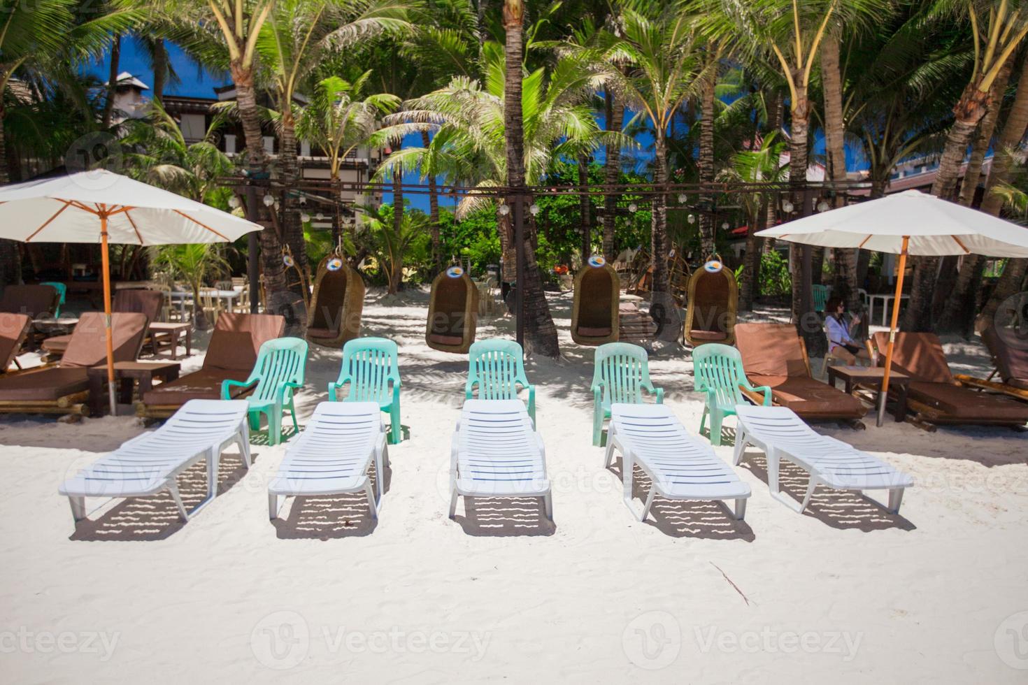 Beach chairs in exotic resort on perfect white sandy beach photo