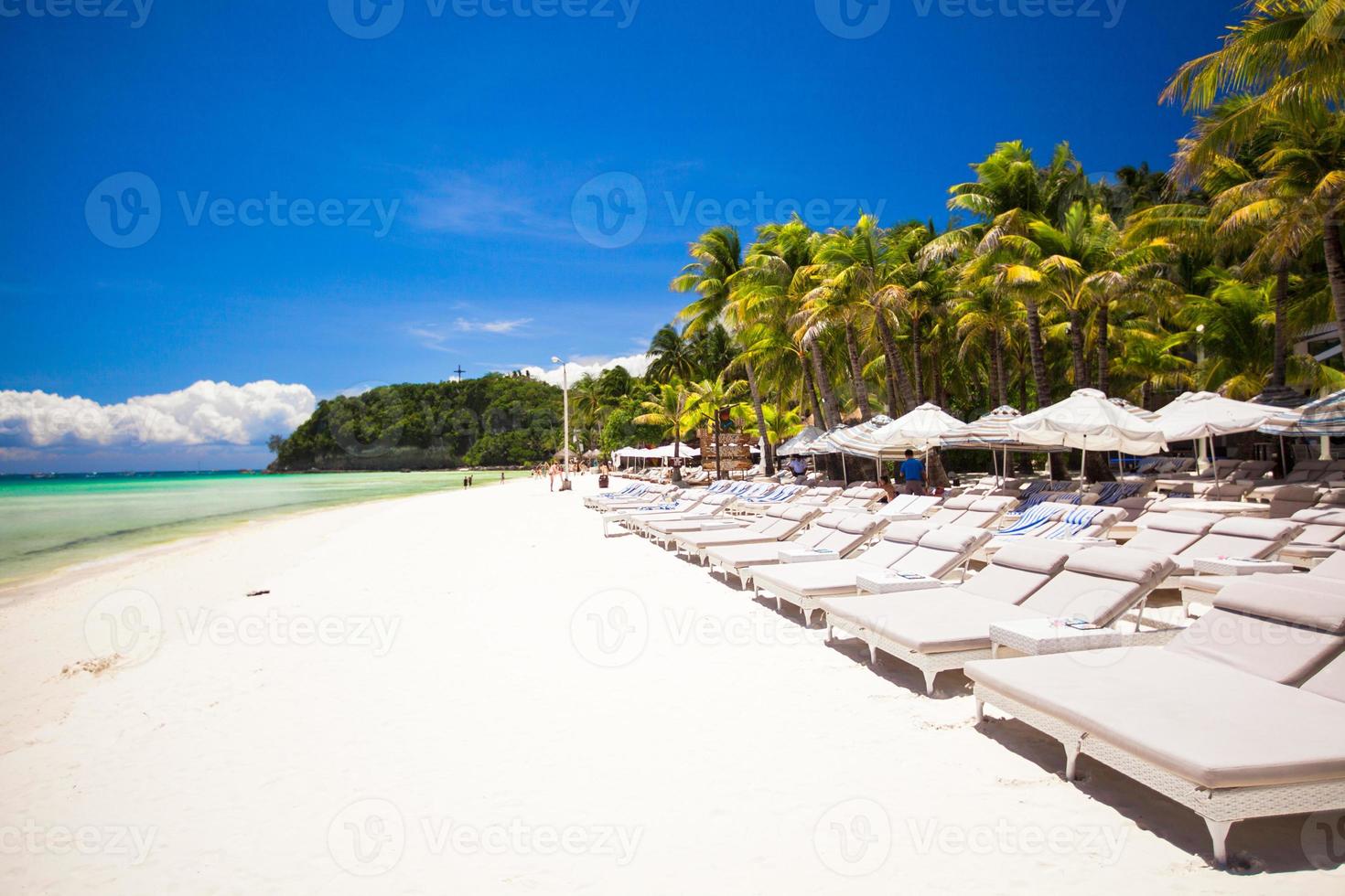 Fantastic view of nice tropical empty sandy plage with umbrella and beach chair photo