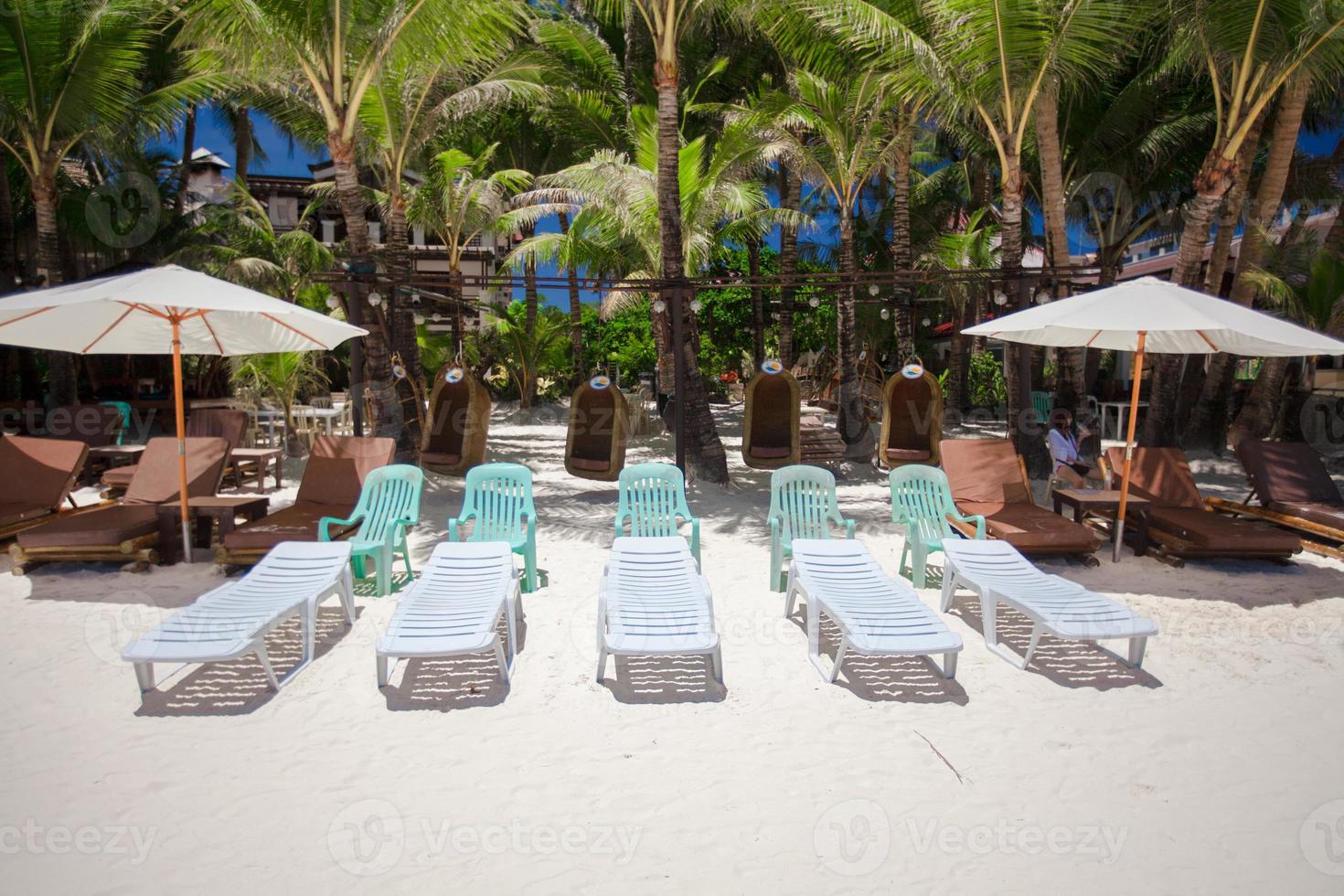 Beach chairs in exotic resort on perfect white sandy beach photo