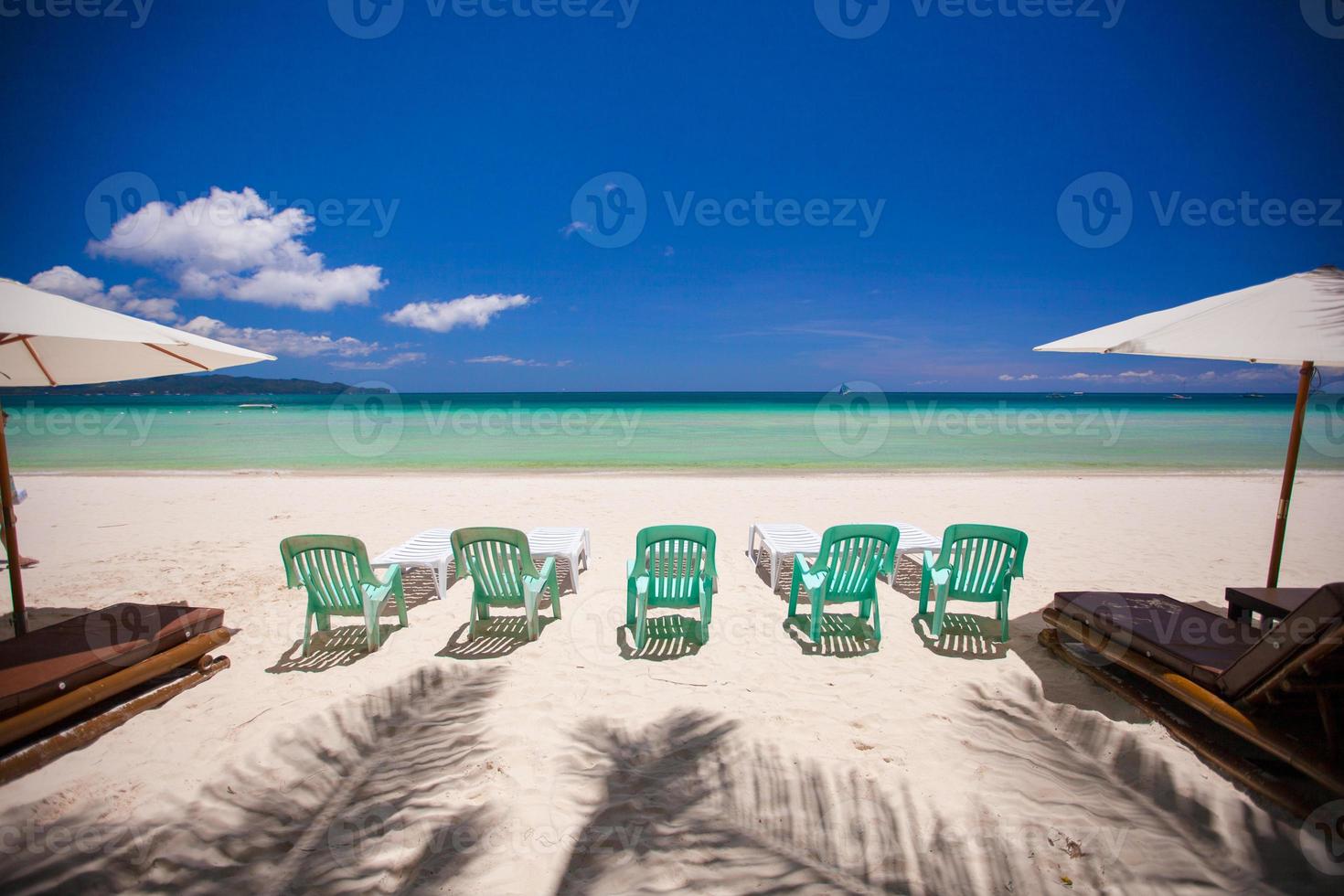 Beach chairs on exotic tropical white sandy beach photo