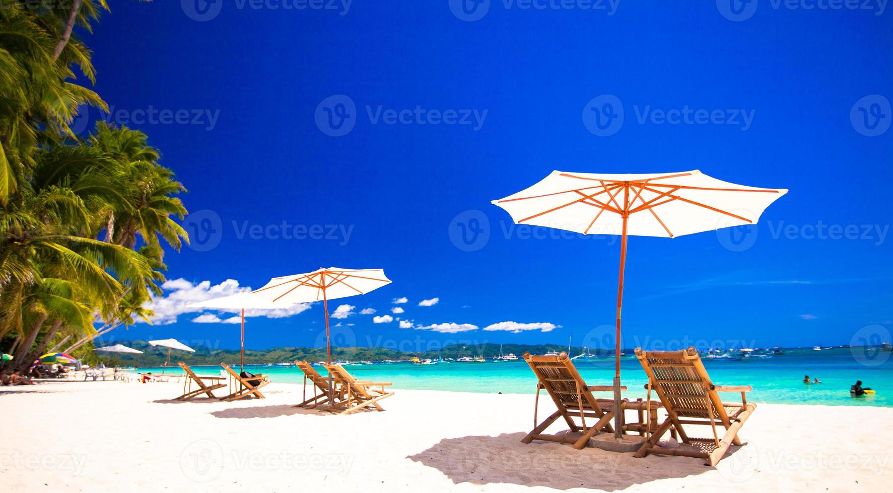 Paradise view of nice tropical empty sandy plage with umbrella and beach chair photo