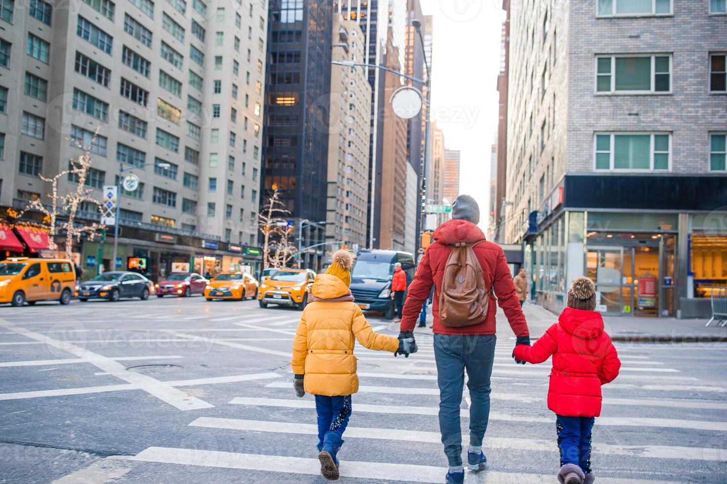 Family of father and little kids on Times Square during their vacation in New York City photo