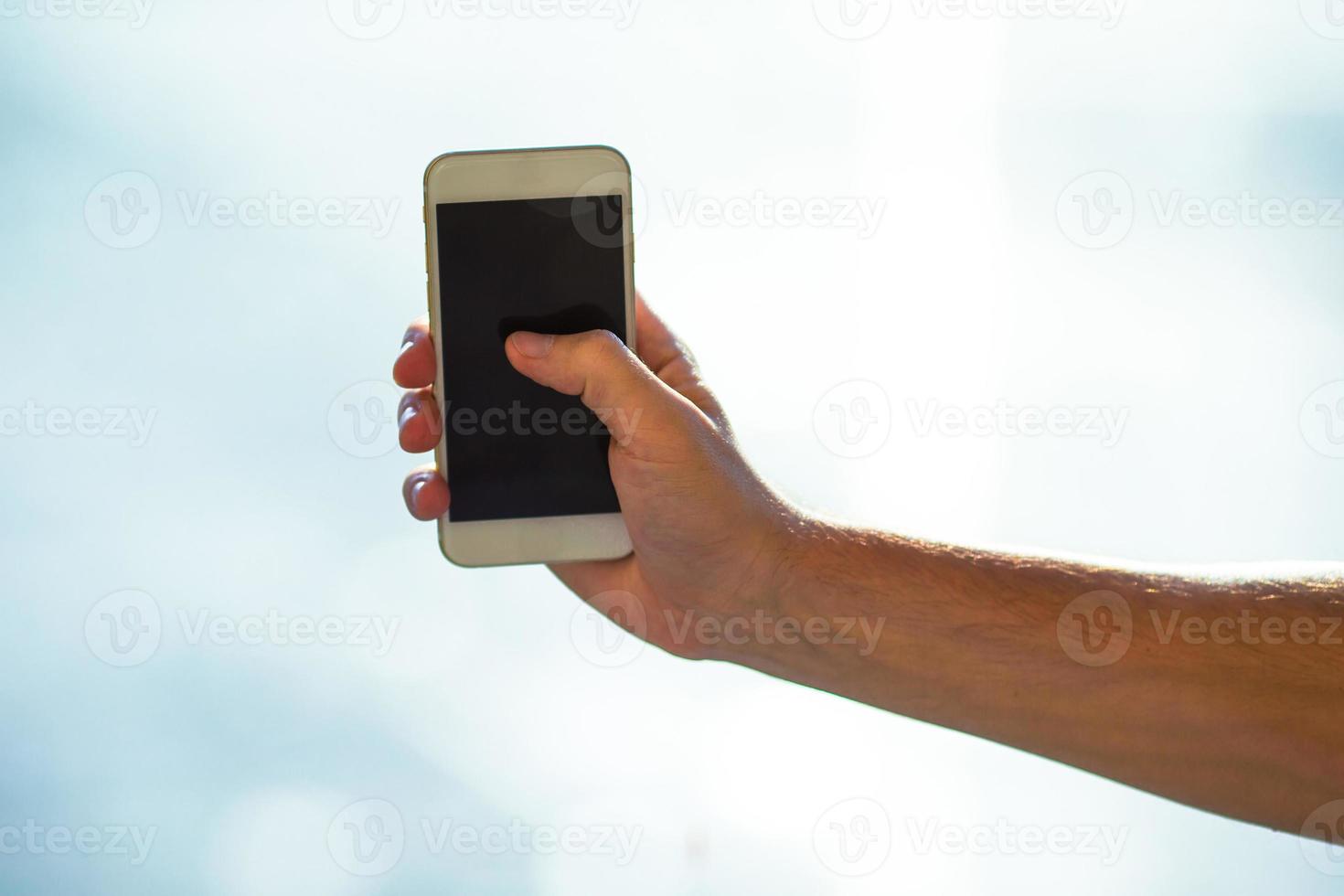 Closeup of young man use smart phone in airport background window photo