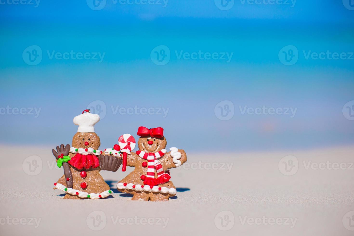 galletas de hombre de pan de jengibre de navidad en una playa de arena blanca foto