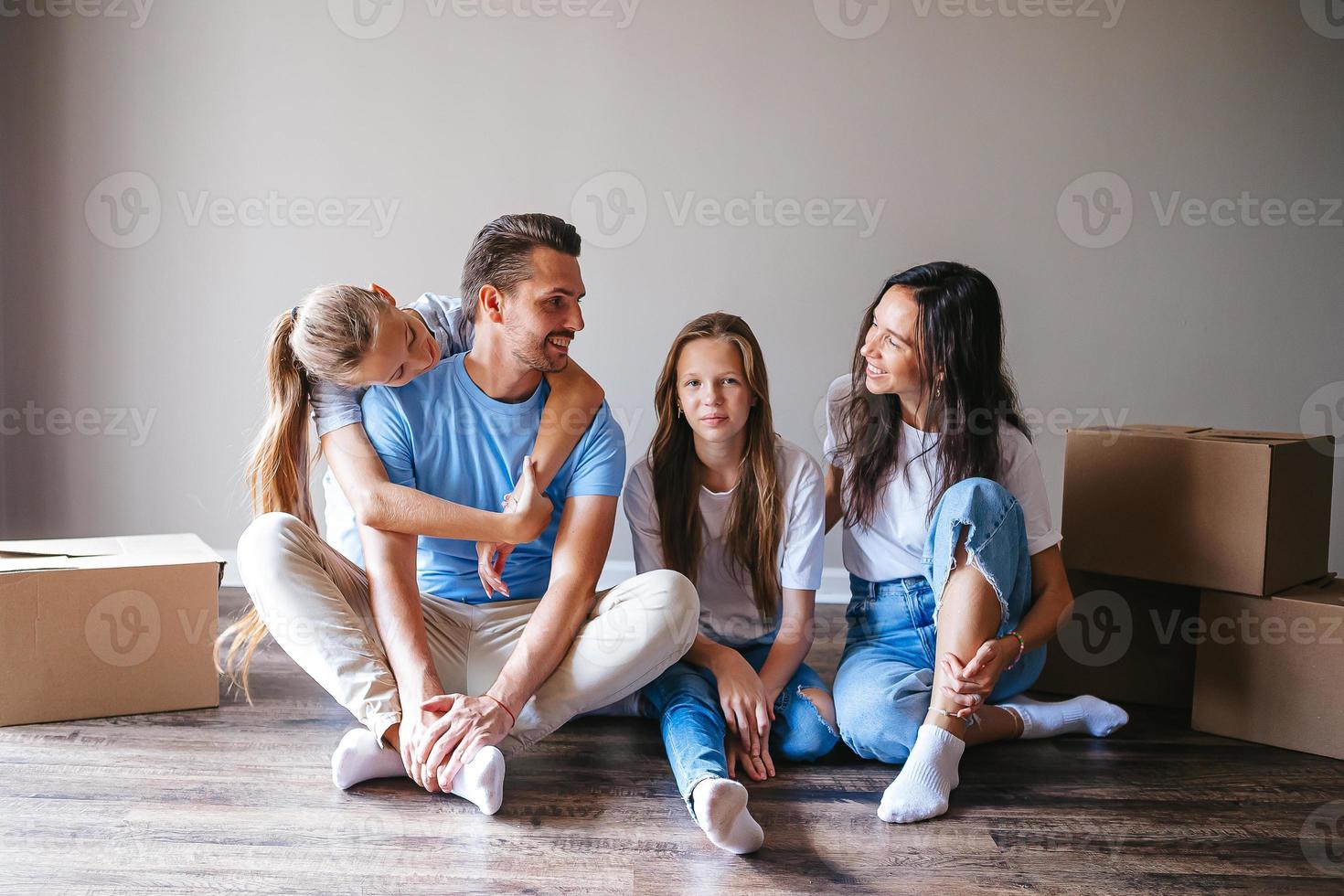 Happy family with two daughters have fun in their new home. Parent with kids enjoy their moving day photo