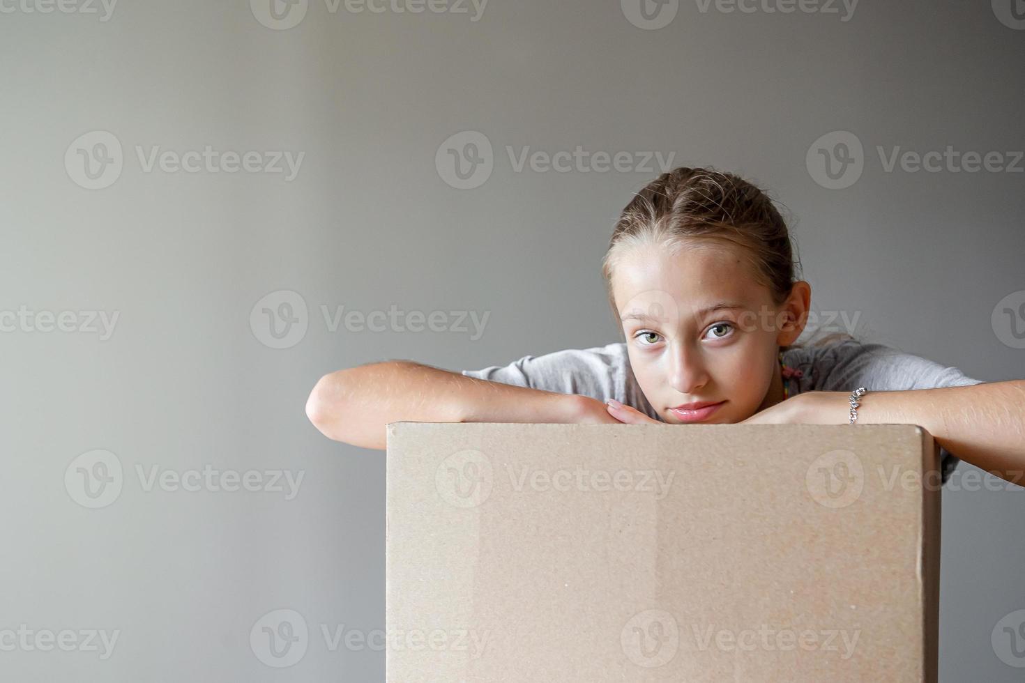 Happy adorable girl with cardboard boxes in new house at moving day photo