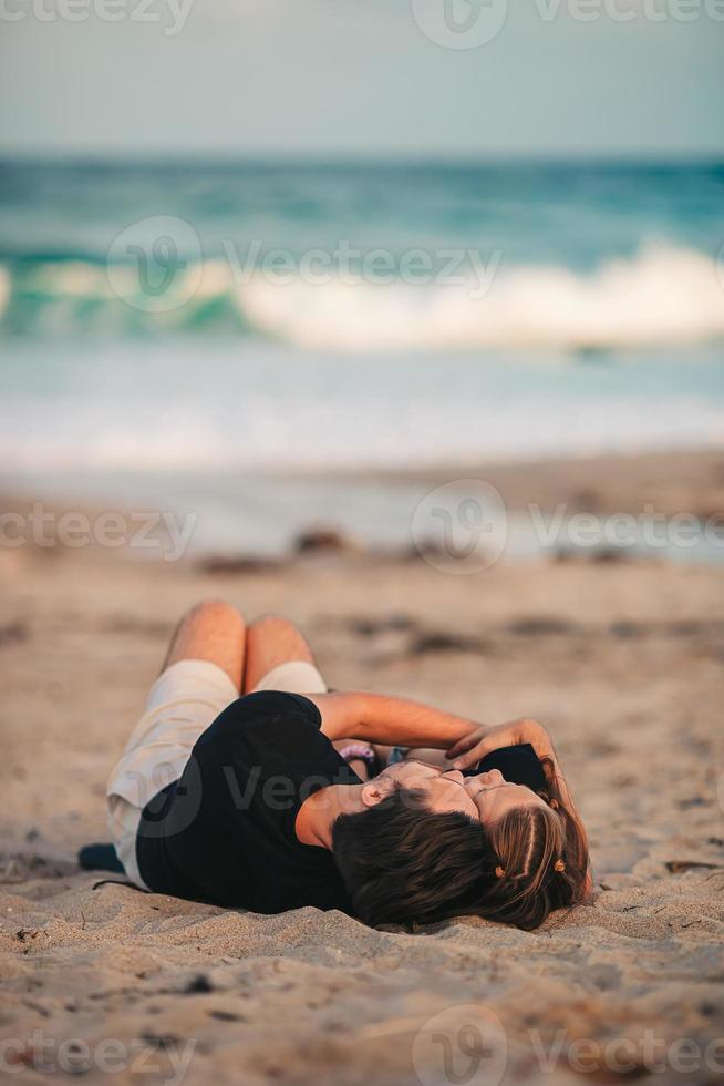 la niña y su padre feliz se relajan en la playa foto