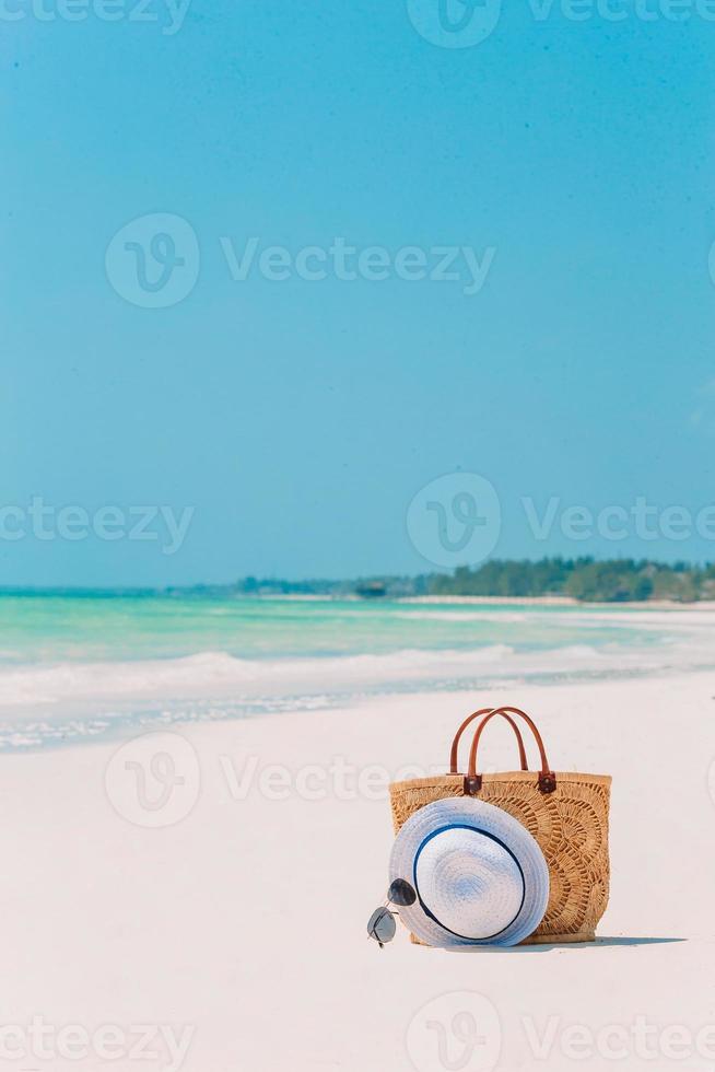 Beach accessories - straw bag, hat and unglasses on the beach photo