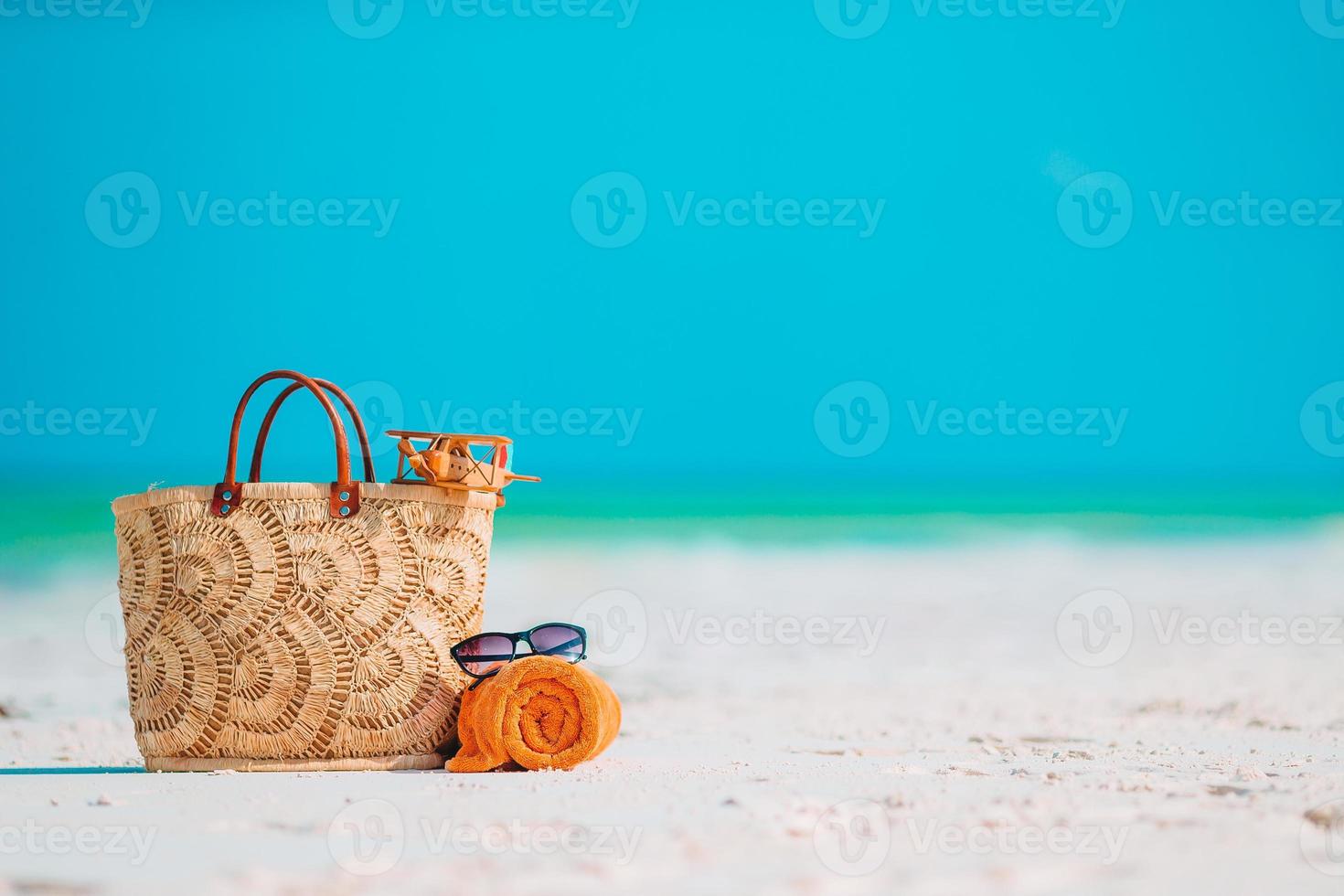 Beach accessories - bag, straw hat, sunglasses on white beach photo