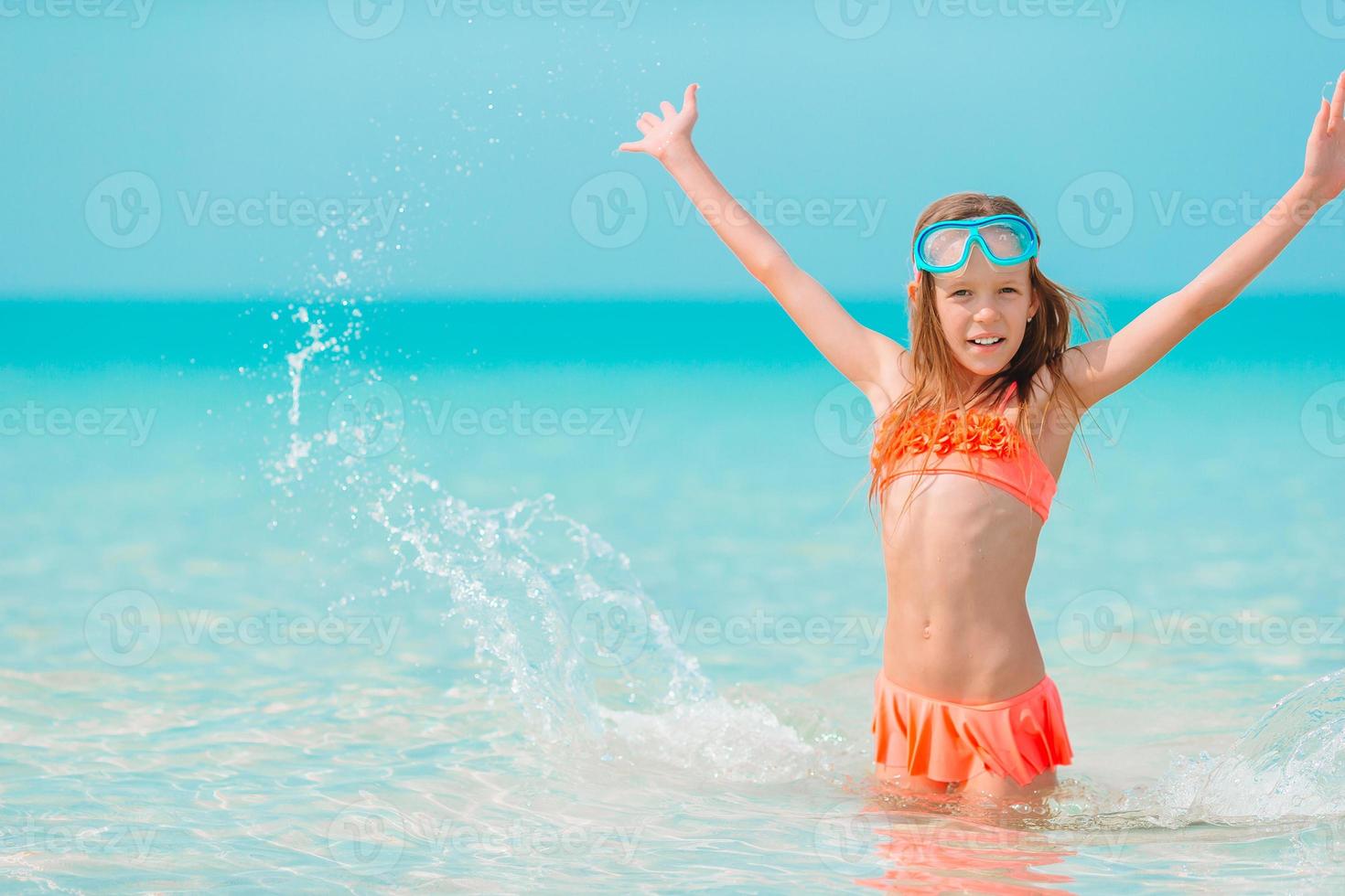 Adorable little girl have fun at tropical beach during vacation photo