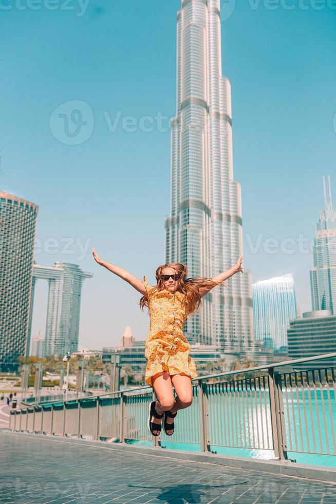 Happy girl walking in Dubai with skyscraper in the background. photo