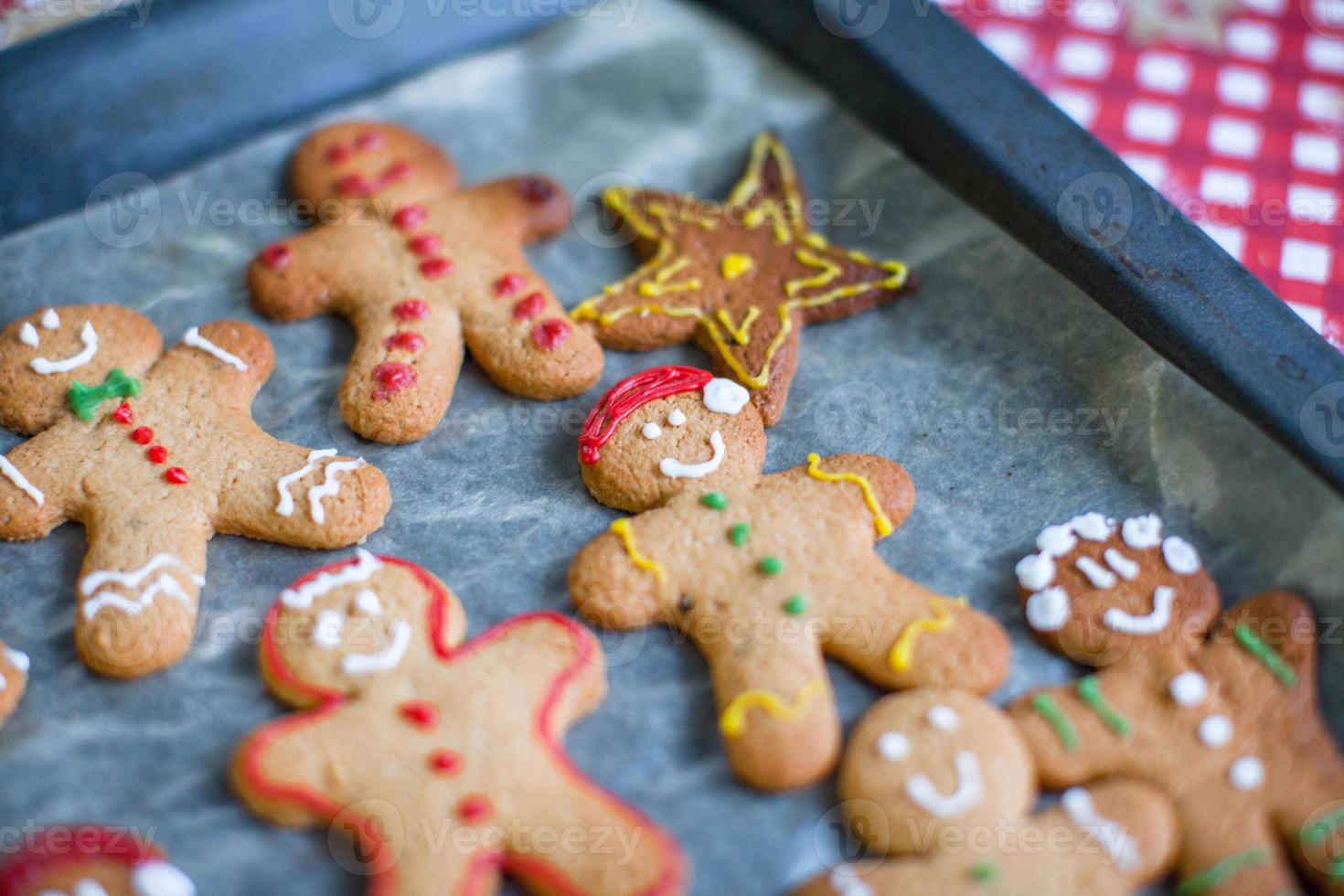 Close-up Raw gingerbread men with glaze on a baking sheet photo