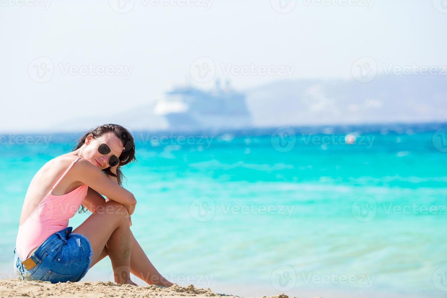 mujer hermosa joven en la playa durante las vacaciones tropicales. chica disfruta de su fin de semana en una de las hermosas playas de grecia, europa. foto