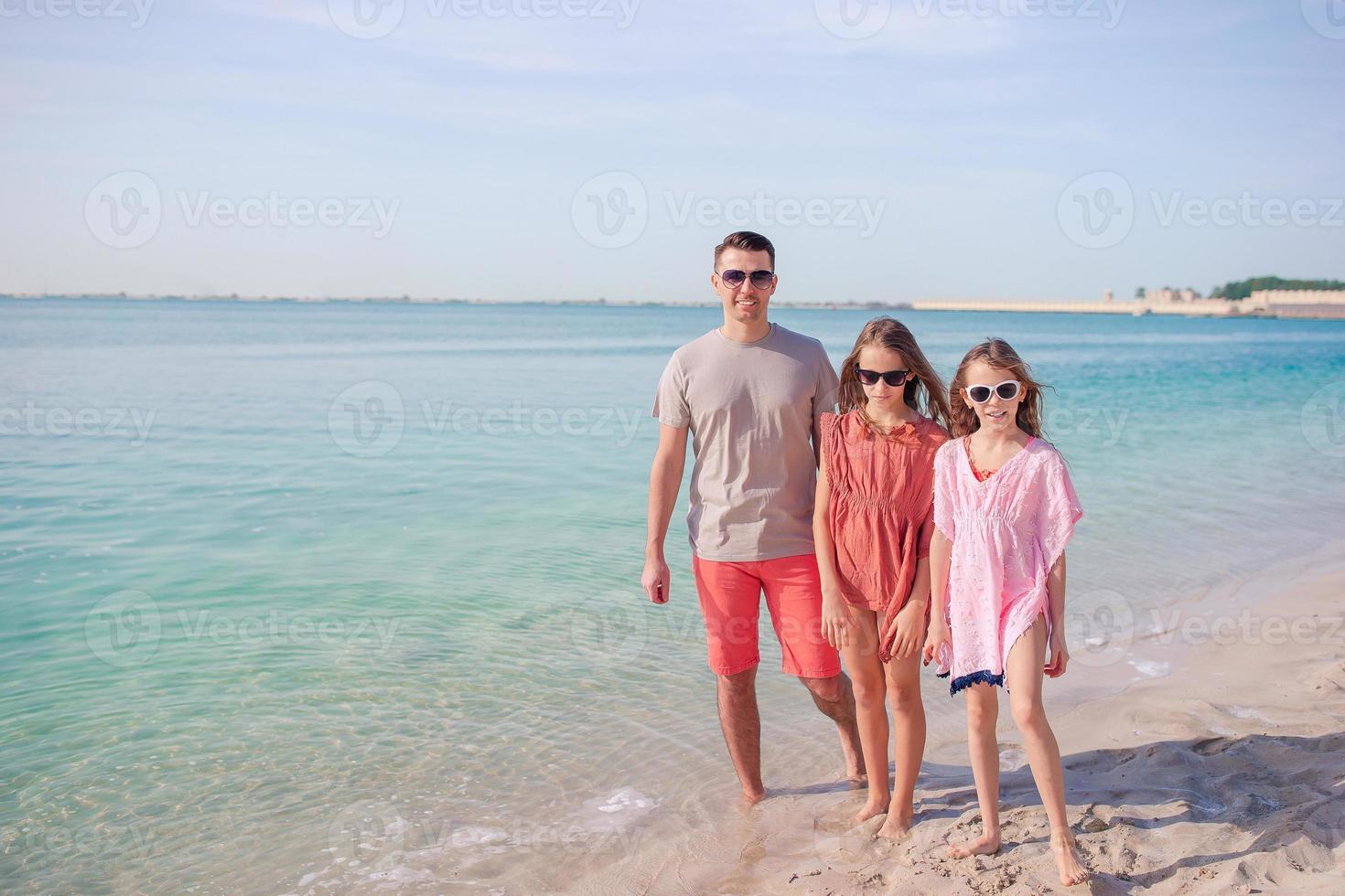 hermosa familia feliz en unas vacaciones en la playa tropical foto