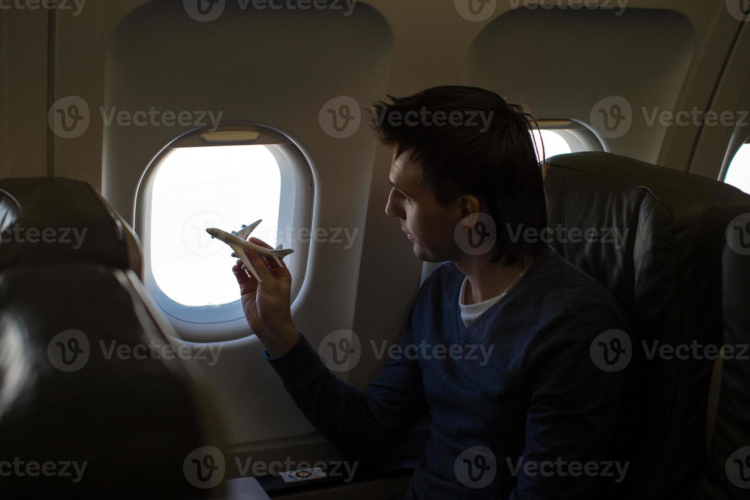 Young man with small model airplane inside a large aircraft photo