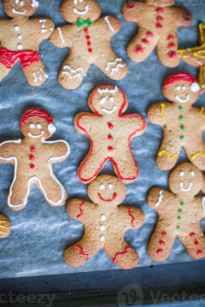 Close-up Raw gingerbread men with glaze on a baking sheet photo