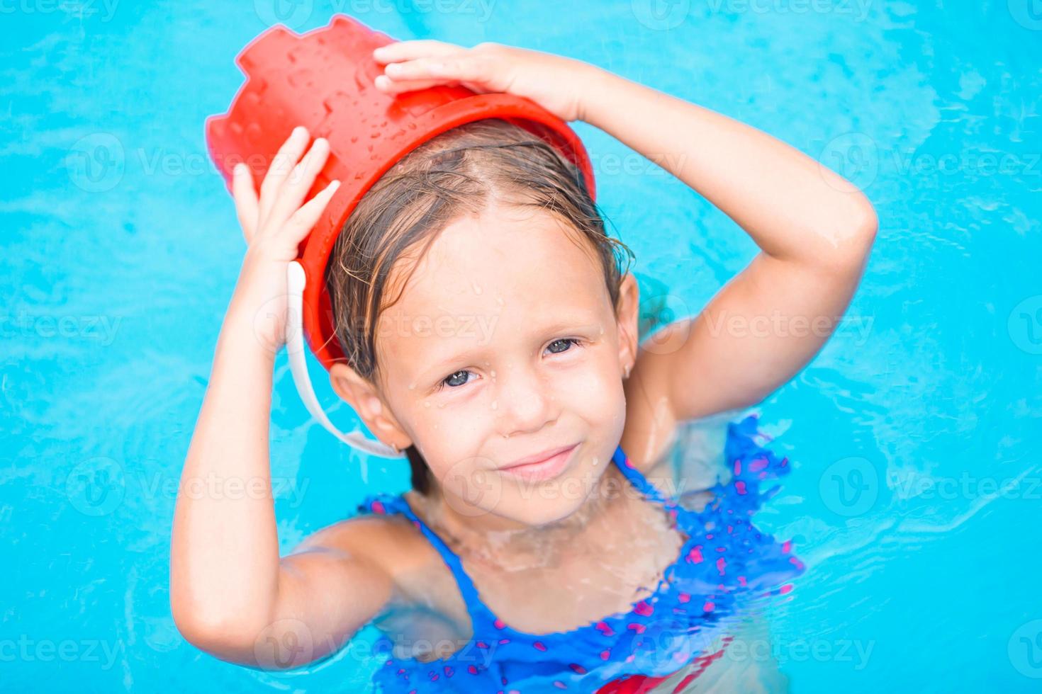 Little adorable girl in outdoor swimming pool photo