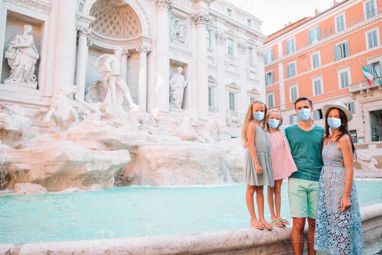 Happy family near Fontana di Trevi in masks photo