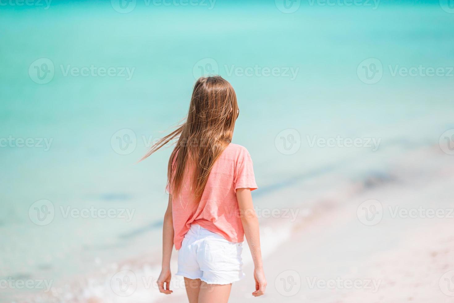 una niña adorable se divierte en la playa tropical durante las vacaciones foto