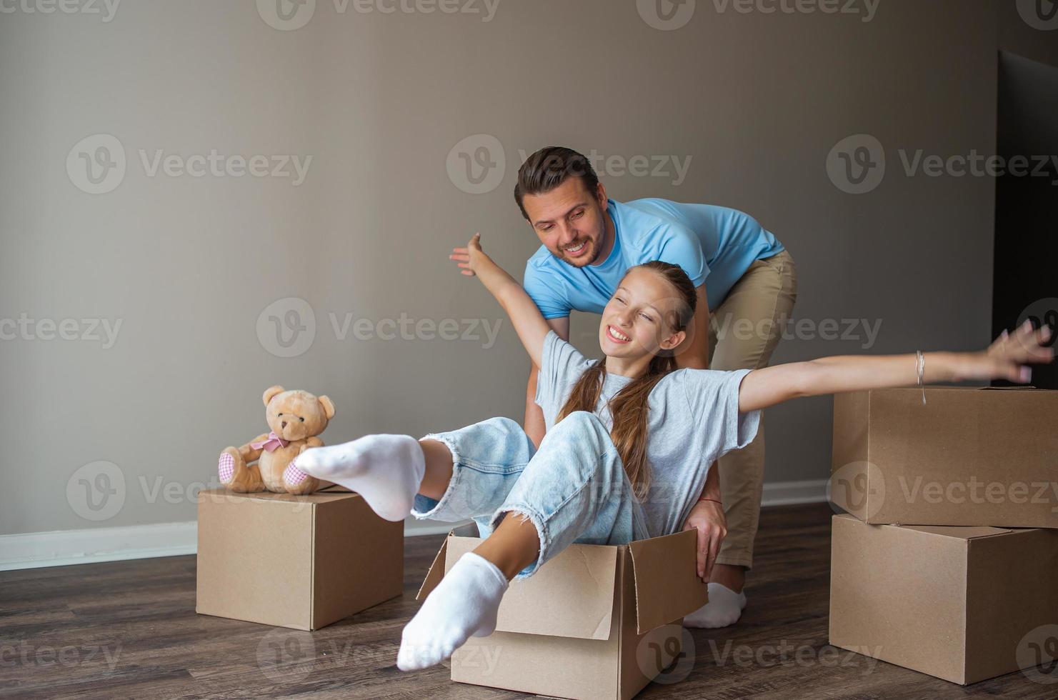 Family of father and adorable teen daughter have fun on moving day in their new home photo