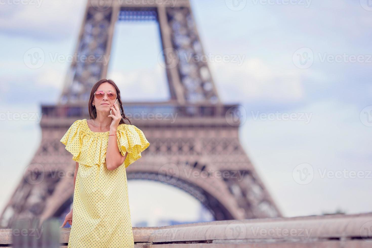 mujer joven hablando por teléfono antecedentes torre eiffel en parís foto