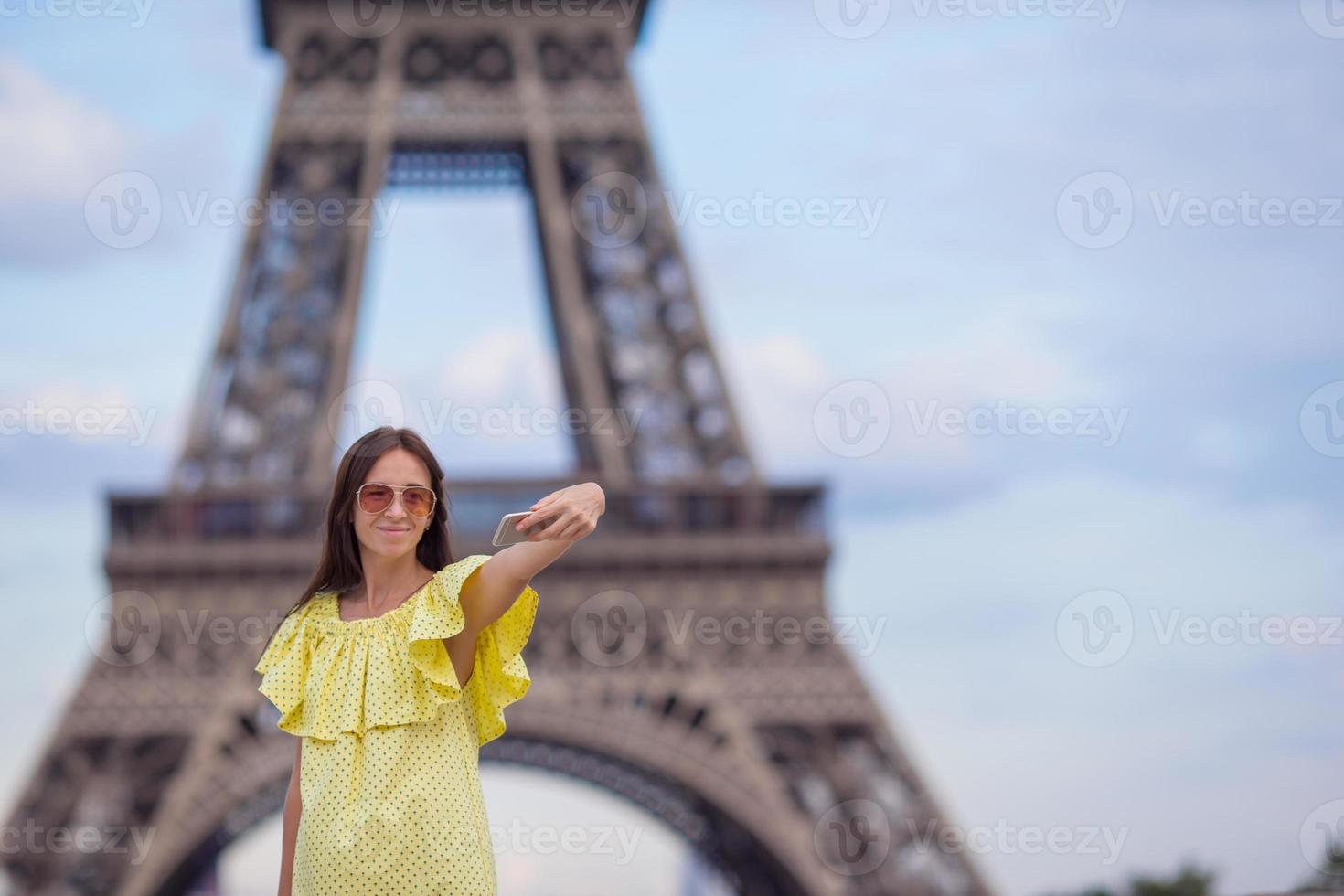 Young woman making selfie - self portrait by phone background Eiffel Tower in Paris photo