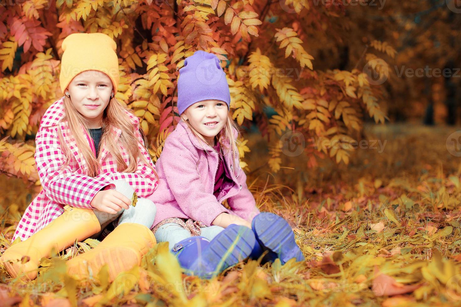 Little adorable girls at warm sunny autumn day outdoors photo