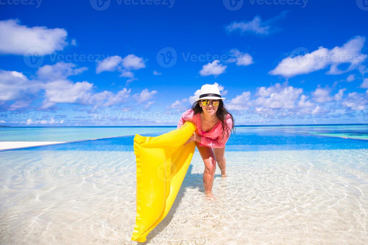 Young happy woman relaxing with air mattress during tropical vacation photo