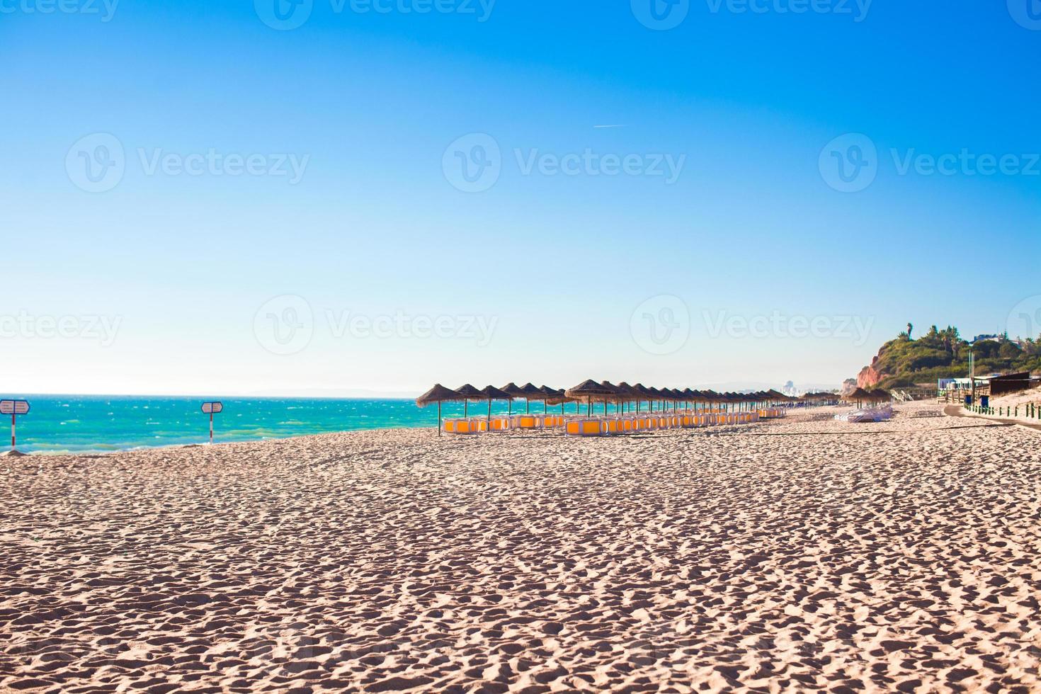 playa vacía con sombrillas cerradas temprano en la mañana en la costa portuguesa foto