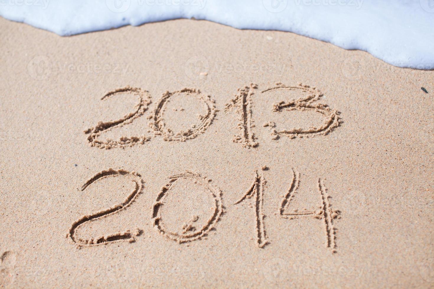 2012 and 2013 written in sand on beach photo