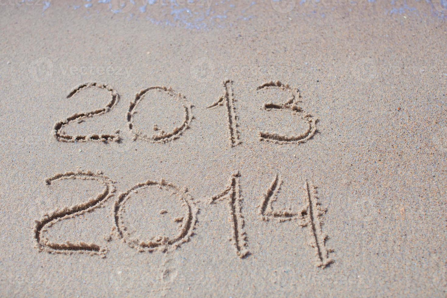 2012 and 2013 written in sand on beach photo