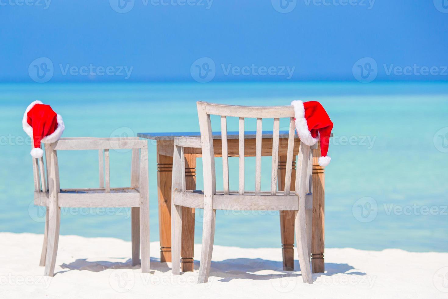 concepto tropical de navidad, café de playa con sombreros rojos de santa foto