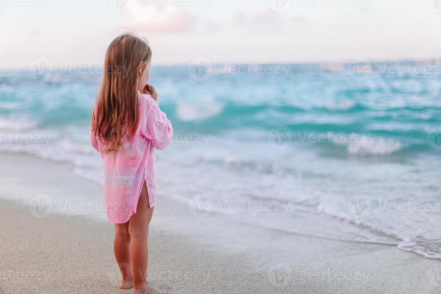 Adorable little girl have fun at tropical beach during vacation photo