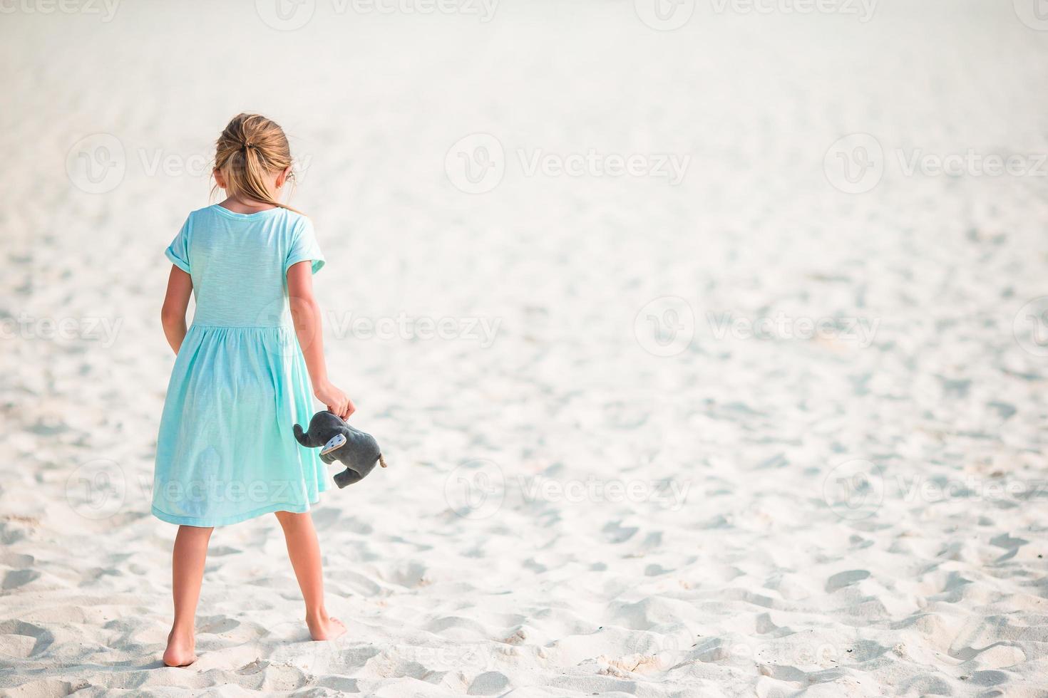 Adorable little girl have fun at tropical beach during vacation photo