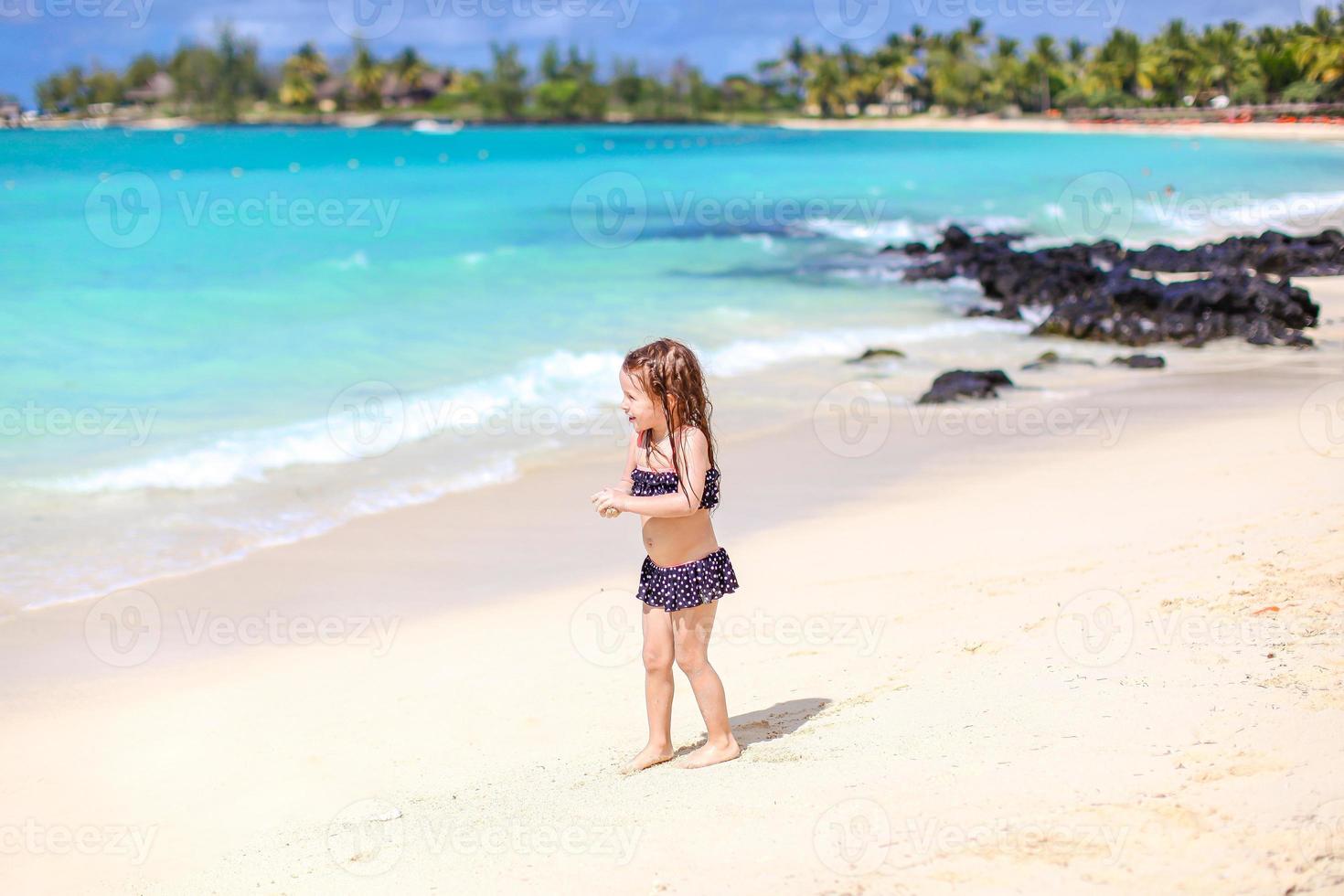 Active little girl at beach having a lot of fun. photo