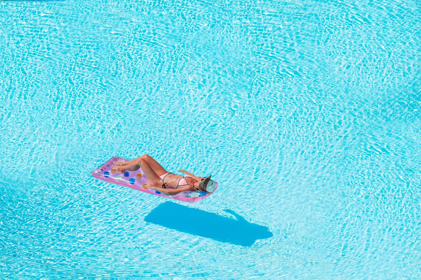 Young woman in bikini air mattress in the big swimming pool photo