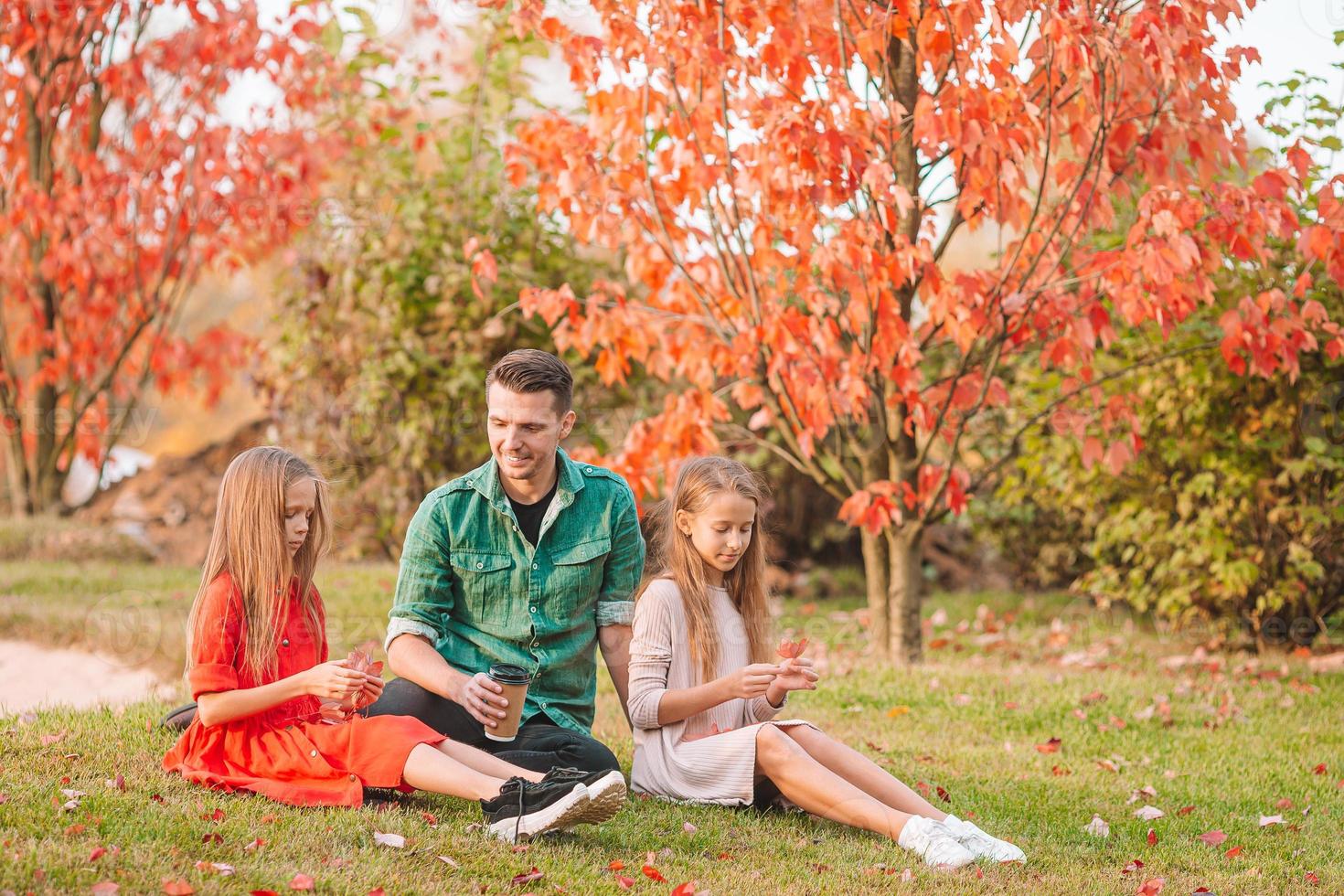 Family of dad and kids on beautiful autumn day in the park photo