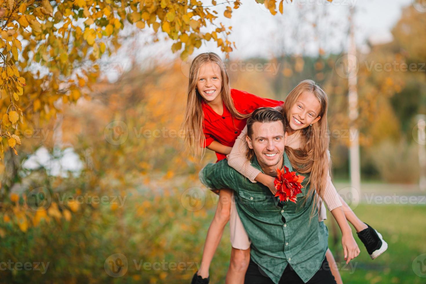 Family of dad and kids on beautiful autumn day in the park photo